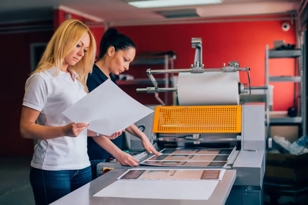 girls in front of print machine